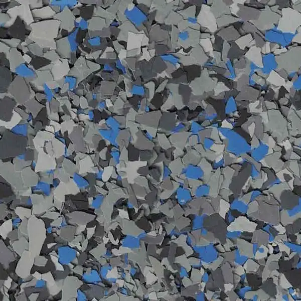 The image shows a close-up of a speckled epoxy floor with gray, black, and blue flakes, creating a textured appearance.