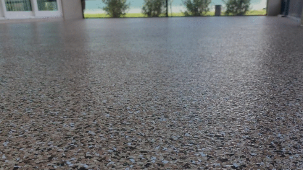 Patterned floor leading to a view with greenery and outdoors. Bright light contrasts the detailed surface texture close-up. No landmarks visible.