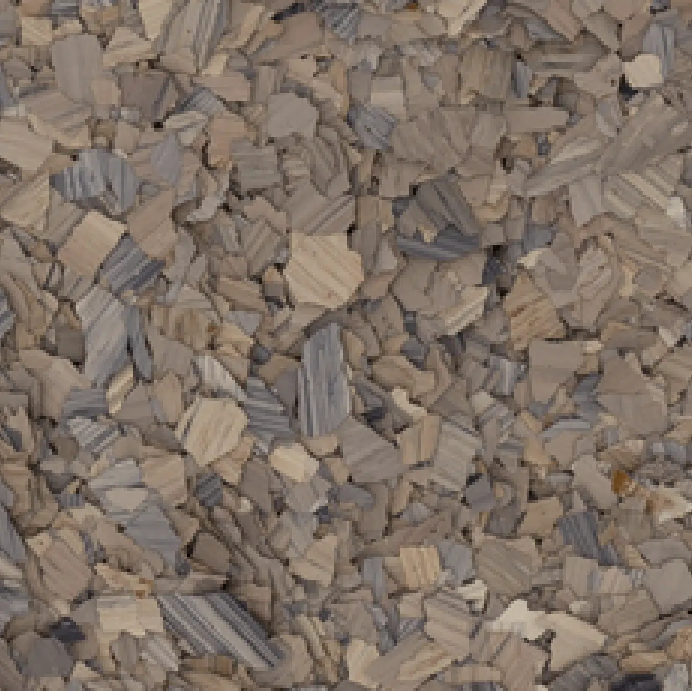 A close-up view of a large pile of grayish-brown wood chips, showcasing various textures and shades in the chips' surfaces.